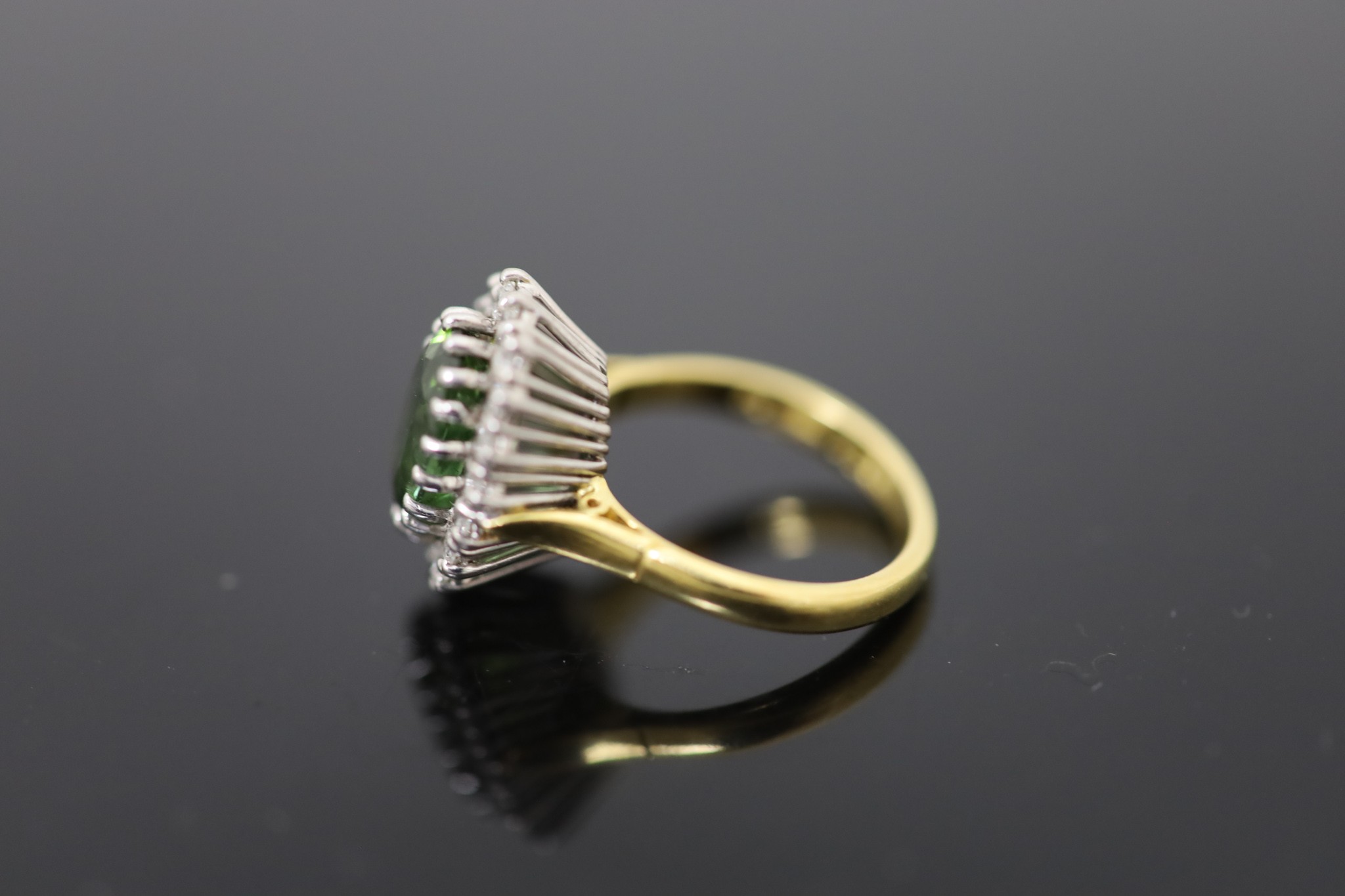 A modern 18ct gold, green tourmaline and diamond set oval cluster ring